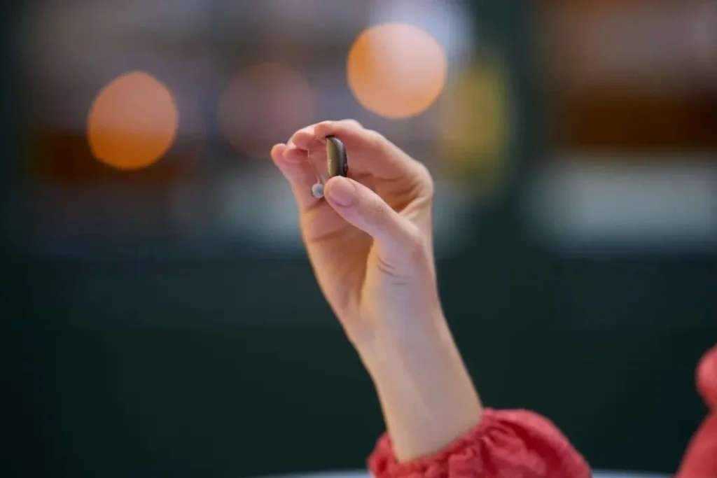 Holding a hearing aid in hand