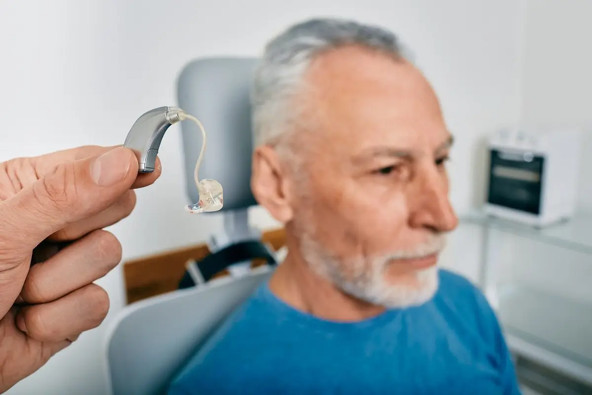 The audiologist is holding a hearing aid