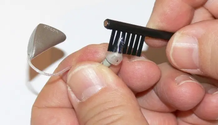 Clean the earplugs of the hearing aid with a brush